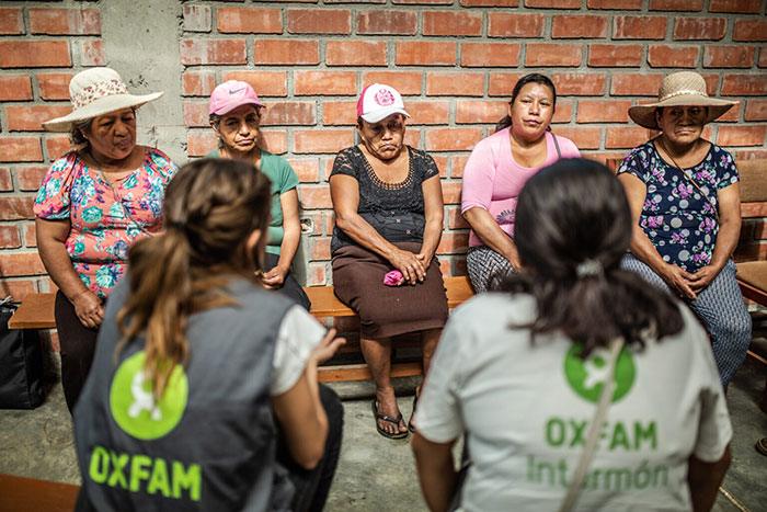 Dos mujeres de OXFAM reunidas con grupo de mujeres