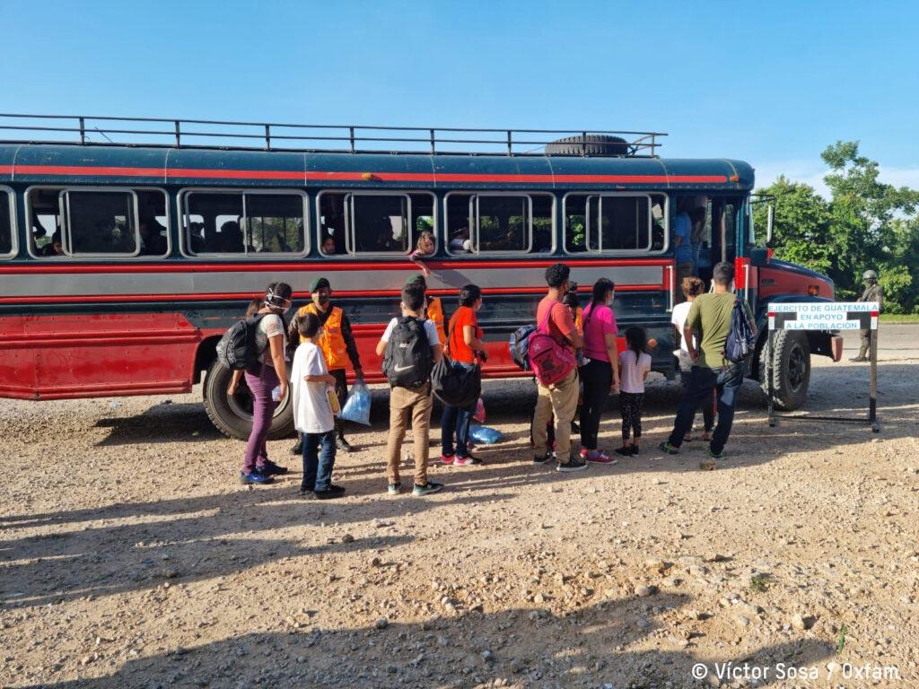 Familias haciendo fila para subir a un bus
